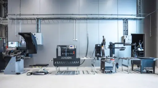 Rivissä vasemmalta: tasapainotuskone, nostotaso, täyttöasema, rata, rengaskone, rata ja palteenirrotin.